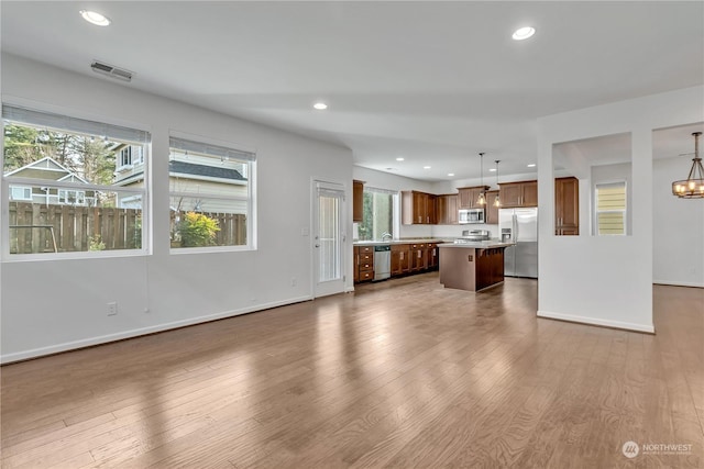 unfurnished living room featuring wood-type flooring and a notable chandelier