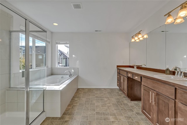 bathroom with vanity and shower with separate bathtub