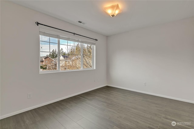 spare room with dark wood-type flooring