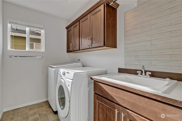 laundry room featuring cabinets, washing machine and clothes dryer, and sink