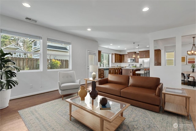 living room featuring an inviting chandelier and light wood-type flooring