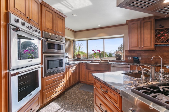 kitchen with crown molding, appliances with stainless steel finishes, dark stone countertops, backsplash, and custom range hood