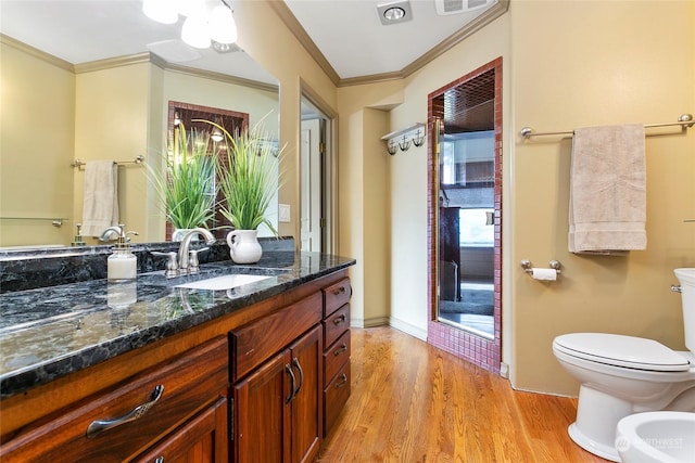 bathroom featuring hardwood / wood-style floors, crown molding, vanity, toilet, and a bidet