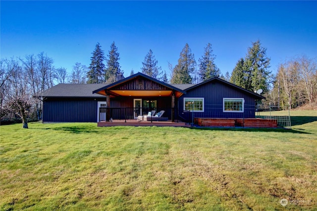 rear view of property featuring a yard and a deck