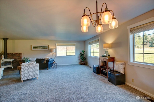 sitting room with carpet floors, a wood stove, and a chandelier