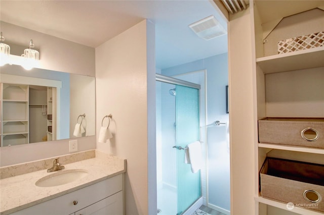 bathroom with vanity and a shower with shower door