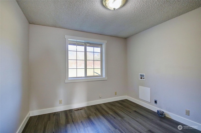 spare room with dark wood-type flooring and a textured ceiling