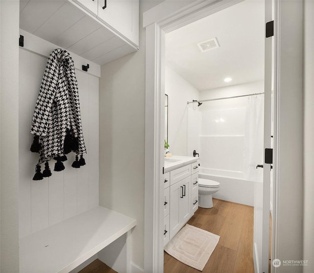 full bathroom featuring vanity, wood-type flooring, shower / bath combination with curtain, and toilet