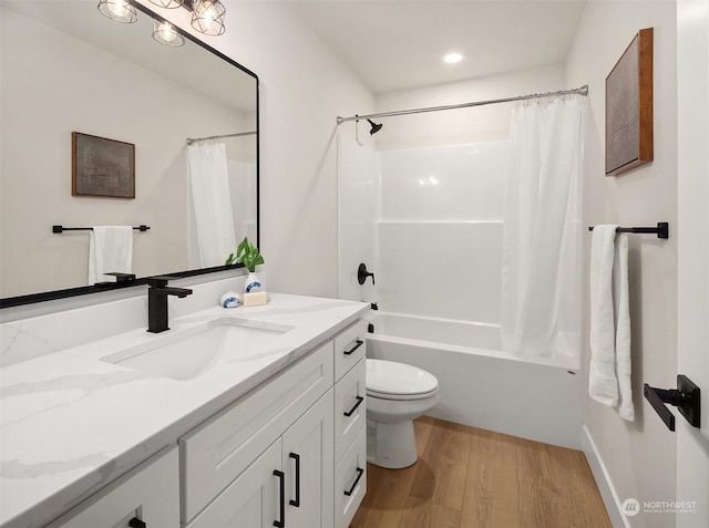 full bathroom with shower / tub combo with curtain, vanity, toilet, and hardwood / wood-style floors