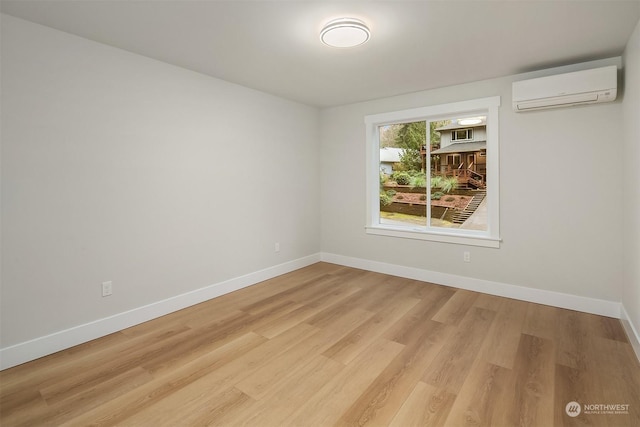 unfurnished room with a wall unit AC and light wood-type flooring