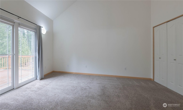 unfurnished bedroom featuring access to outside, light colored carpet, high vaulted ceiling, and a closet