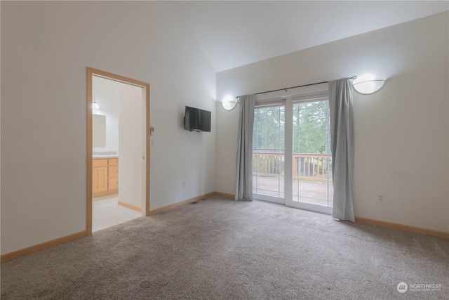 carpeted spare room featuring high vaulted ceiling