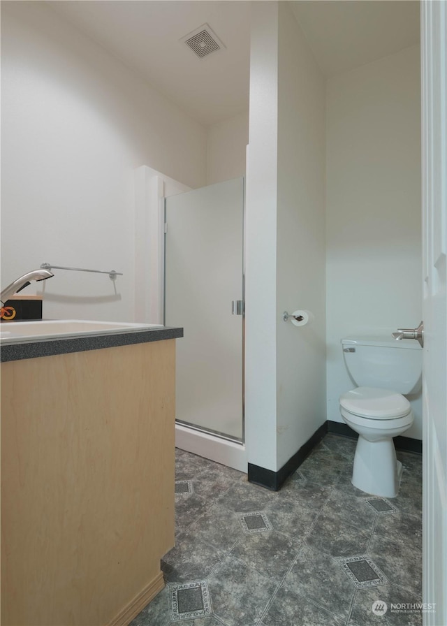 bathroom with vanity, a shower with shower door, and toilet