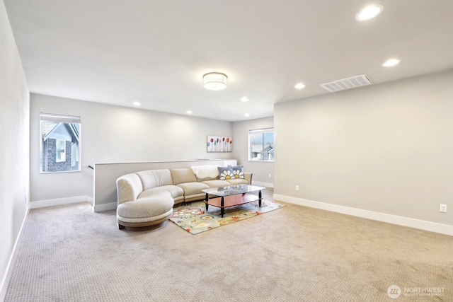 living area with carpet floors, plenty of natural light, visible vents, and baseboards