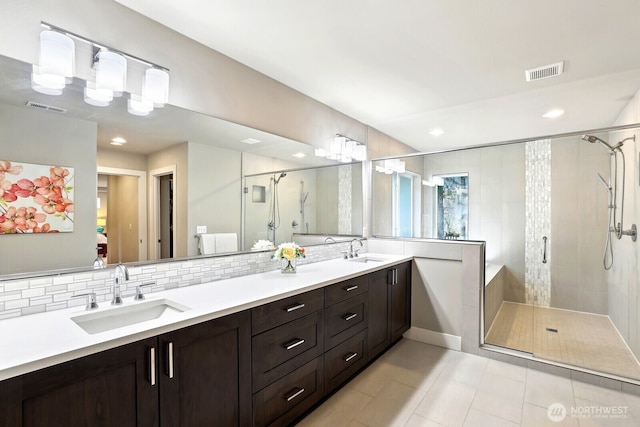 full bathroom featuring a stall shower, a sink, and visible vents