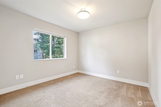 empty room featuring carpet floors and baseboards