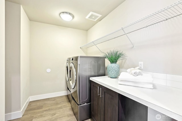 washroom with laundry area, visible vents, baseboards, independent washer and dryer, and light wood finished floors