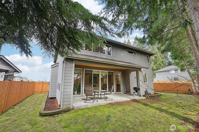 back of house with a patio area, a fenced backyard, and a lawn