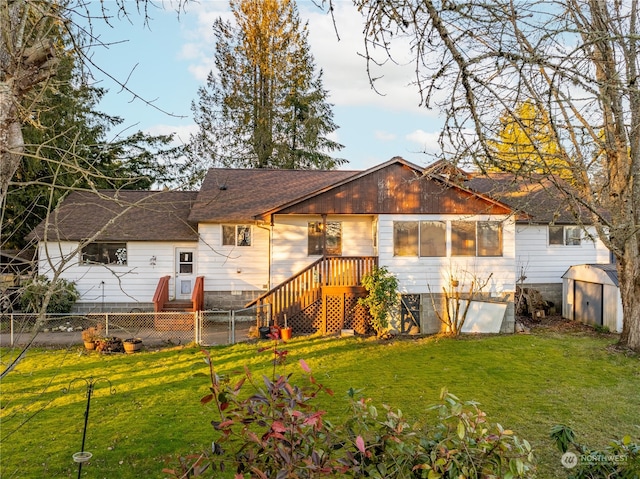 back of house with a yard and a storage unit