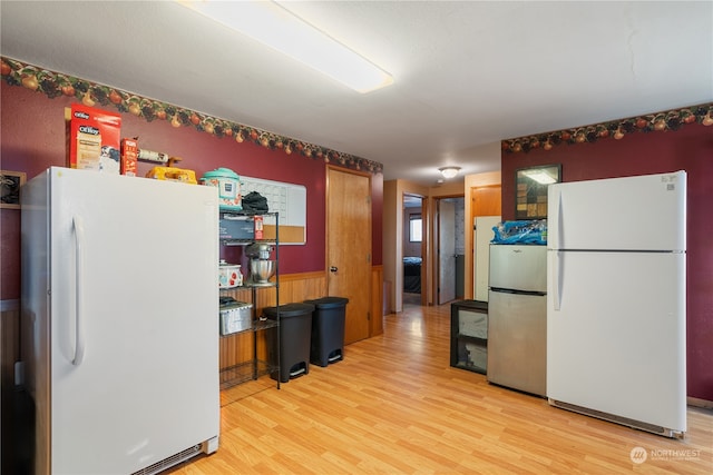 kitchen featuring light hardwood / wood-style flooring, stainless steel refrigerator, and white refrigerator