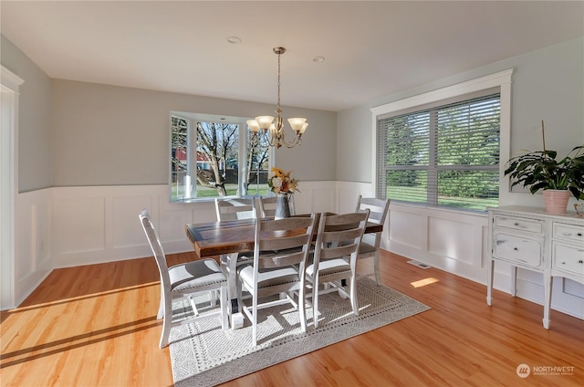 dining area with an inviting chandelier, light hardwood / wood-style floors, and a wealth of natural light