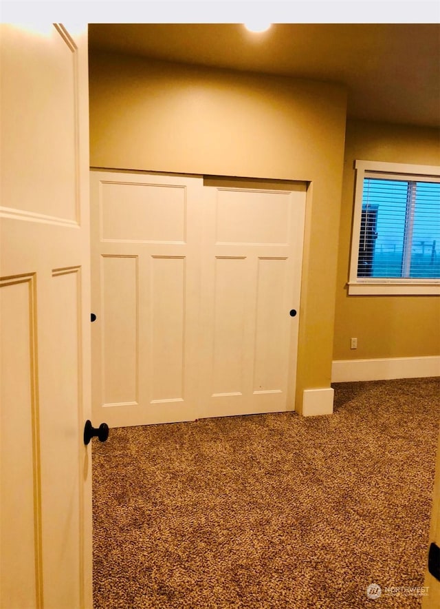 unfurnished bedroom featuring carpet and a closet