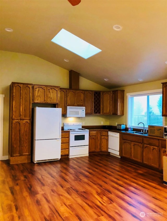 kitchen with dark hardwood / wood-style flooring, sink, white appliances, and lofted ceiling with skylight