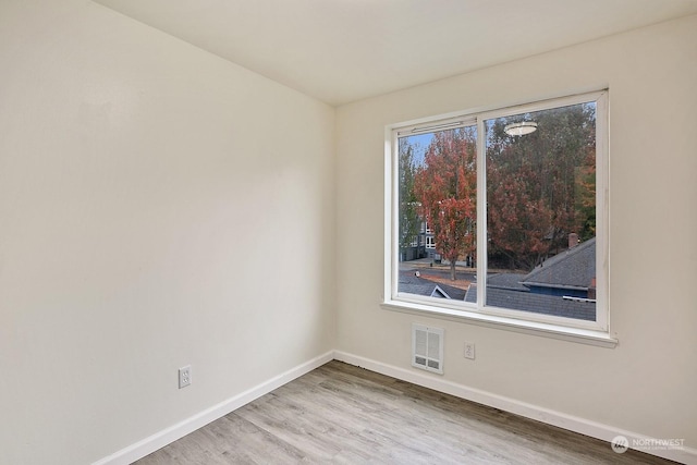 unfurnished room with hardwood / wood-style flooring