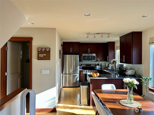 kitchen with sink, light hardwood / wood-style flooring, dark brown cabinets, stainless steel appliances, and tasteful backsplash