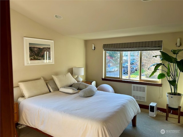 bedroom featuring lofted ceiling, radiator, and carpet