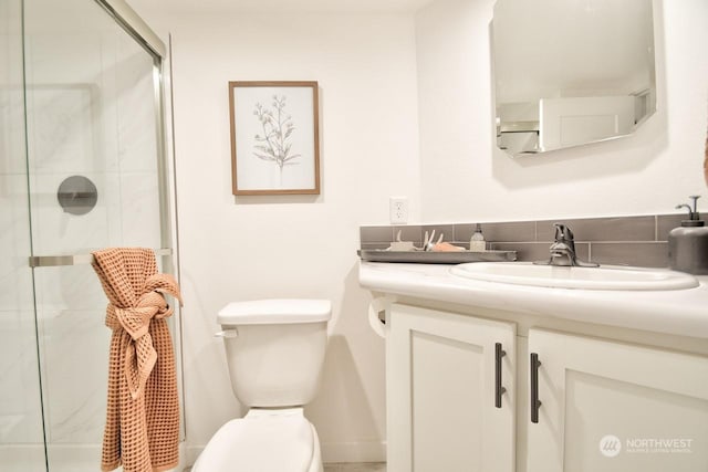 bathroom with vanity, a shower with shower door, and toilet