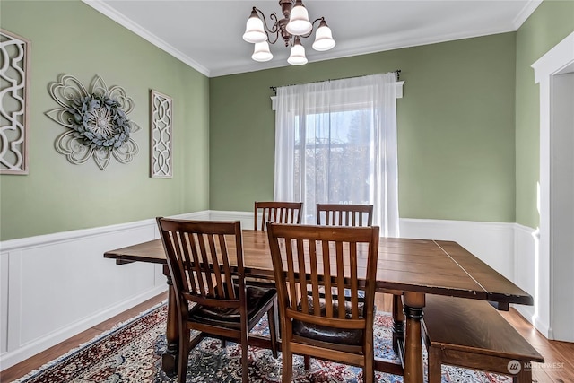 dining room with ornamental molding, hardwood / wood-style floors, and a chandelier