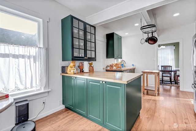 kitchen with light hardwood / wood-style flooring, a wealth of natural light, and green cabinetry