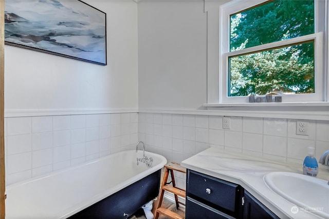 bathroom featuring vanity, tile walls, and a washtub