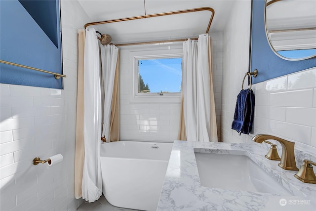 bathroom featuring vanity, tile walls, and shower / bath combination with curtain