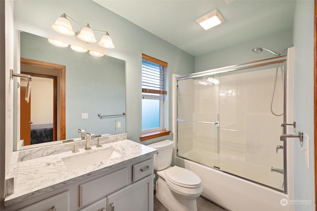 full bathroom featuring vanity, toilet, and combined bath / shower with glass door