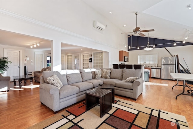 living room with sink, light hardwood / wood-style flooring, ornamental molding, and an AC wall unit