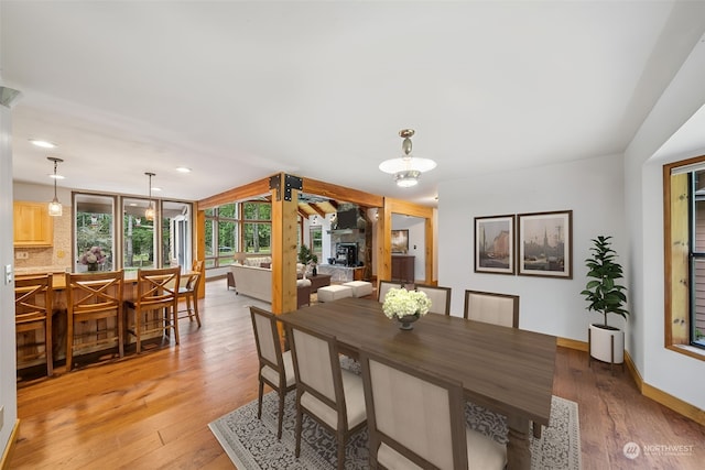 dining area featuring a fireplace and light wood-type flooring