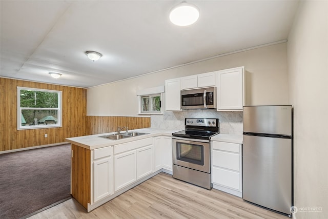 kitchen with stainless steel appliances, a healthy amount of sunlight, sink, and white cabinetry