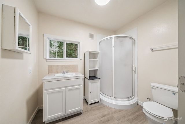 bathroom with vanity, toilet, an enclosed shower, and wood-type flooring