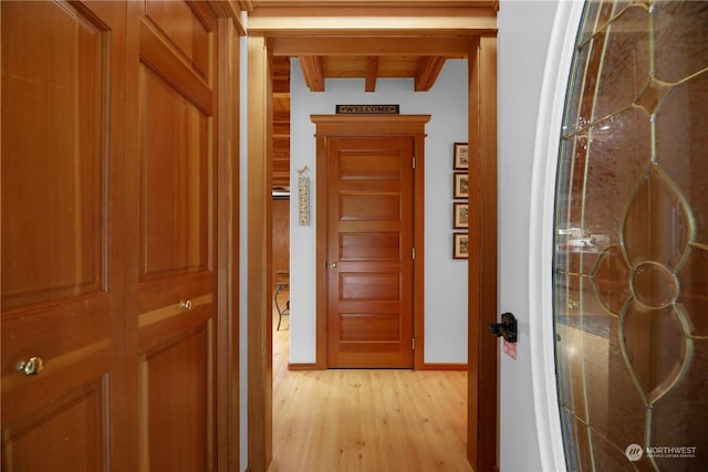 hall with beam ceiling and light hardwood / wood-style flooring