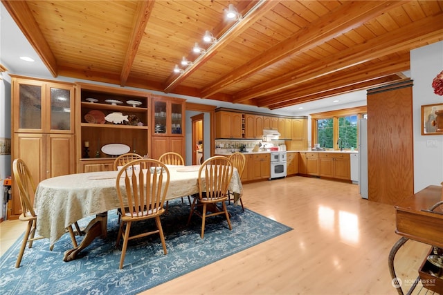 dining space with beam ceiling, wood ceiling, track lighting, and light wood-type flooring