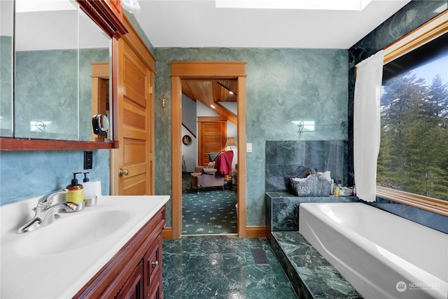 bathroom featuring vanity and a washtub