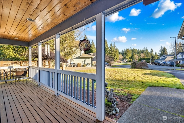 wooden terrace featuring a yard and a porch