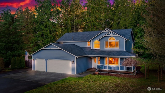 view of front of home featuring a garage, a yard, and covered porch