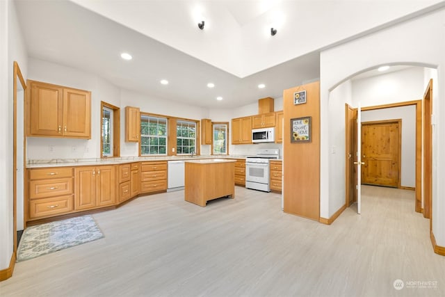 kitchen featuring a center island, white appliances, and light wood-type flooring