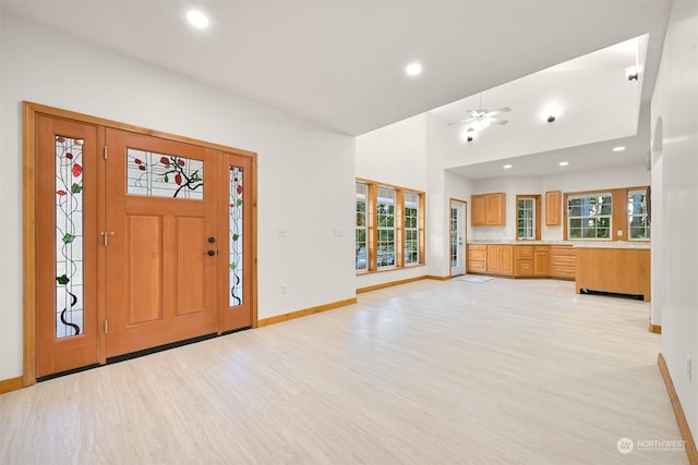 foyer featuring ceiling fan, high vaulted ceiling, and light hardwood / wood-style floors