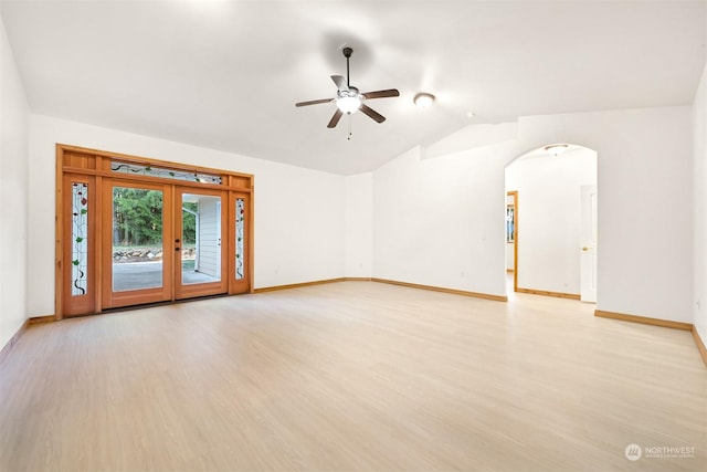 empty room with vaulted ceiling, french doors, ceiling fan, and light wood-type flooring