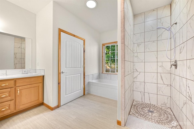 bathroom featuring vanity, plus walk in shower, and hardwood / wood-style floors