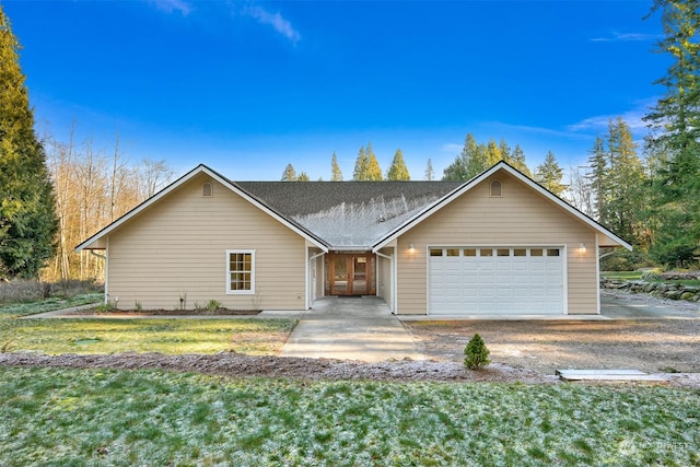 ranch-style house featuring a garage and a front lawn